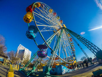 Low angle view of ferris wheel against blue sky