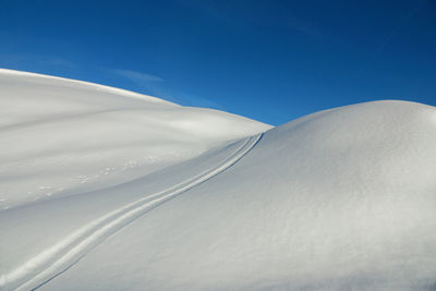 Low angle view of desert against clear blue sky