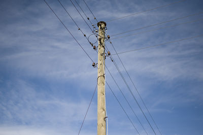 Low angle view of electricity pylon against sky