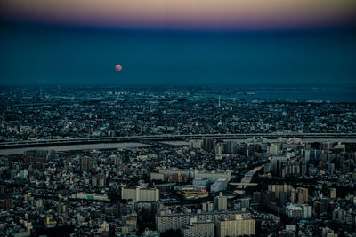 High angle view of illuminated cityscape against sky at night