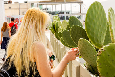 Rear view of woman holding plant