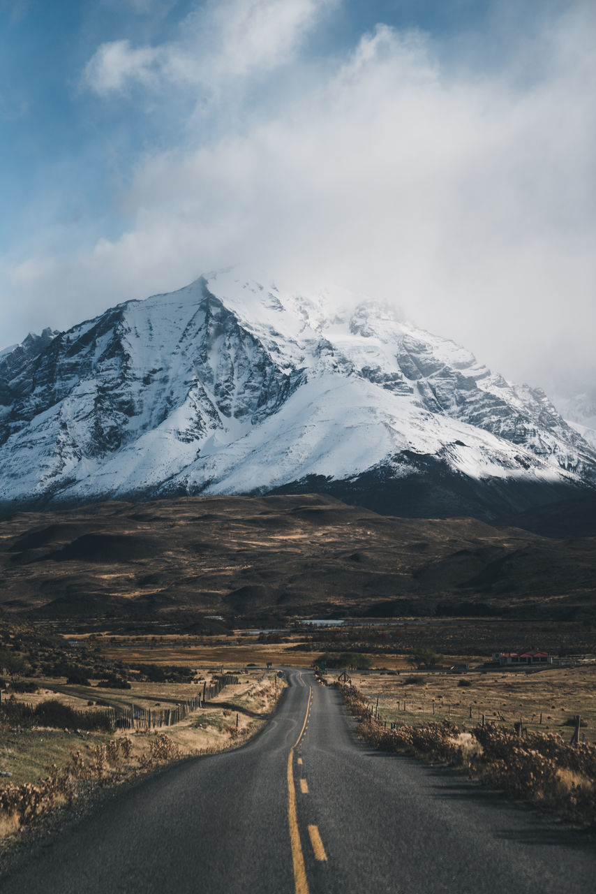 mountain, road, direction, sky, cloud - sky, beauty in nature, the way forward, scenics - nature, snow, cold temperature, winter, mountain range, landscape, transportation, environment, tranquil scene, non-urban scene, nature, symbol, no people, diminishing perspective, snowcapped mountain, outdoors, dividing line