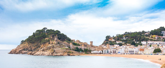 Panoramic view of sea and buildings against sky