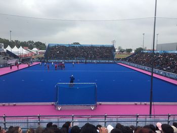 High angle view of people playing soccer by crowd in stadium