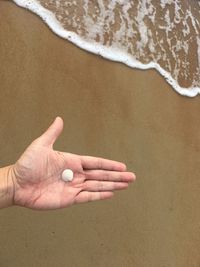 High angle view of hands on sand at beach