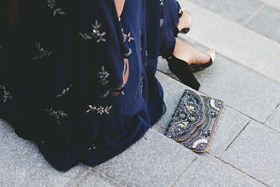 Low section of woman sitting outdoors