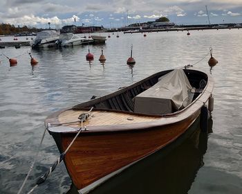Sailboats moored on sea against sky