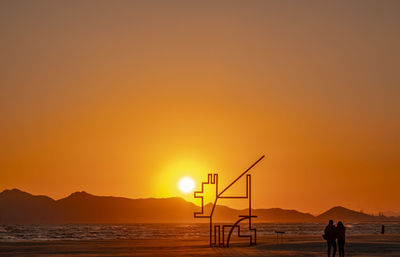 Scenic view of sea against orange sky