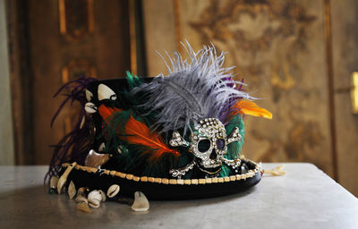 Close-up of feather and skull on hat