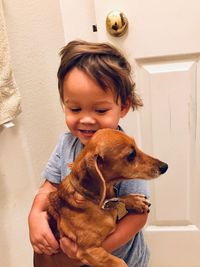 Cute boy with dog at home