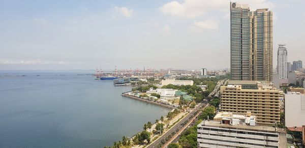 High angle view of buildings by sea against sky