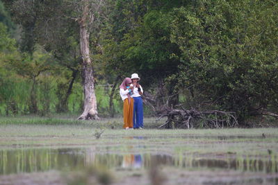 Rear view of woman standing in lake