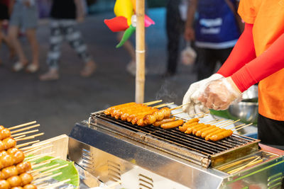 Chef grilled meat ball and sausage on smokeless grill in street food market