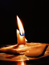 Close-up of illuminated candle against black background