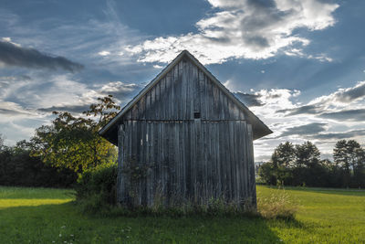 Barn on field against sky