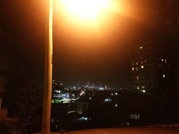 Illuminated buildings against sky at night