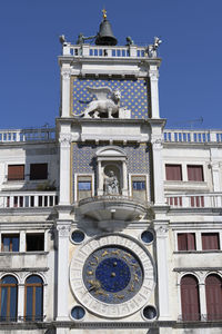 Low angle view of clock tower against blue sky