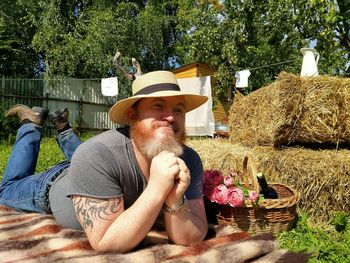 Portrait of man with hat on plants against trees