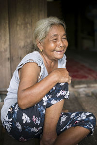 A single indigenous woman sitting and smiling