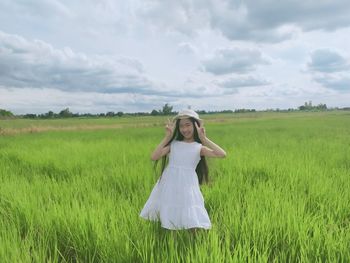 Full length of woman standing on field against sky