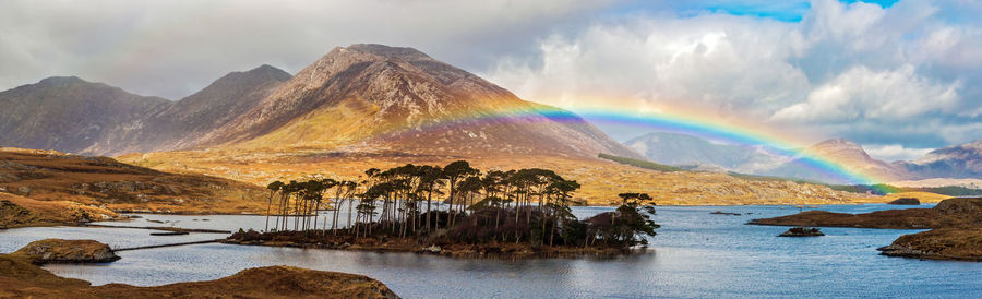 Panoramic view of rainbow over mountains against sky