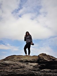 Low angle view of man standing on rock