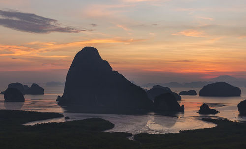 Rocks on sea against sky during sunset