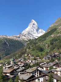 Scenic view of snowcapped mountains against clear blue sky