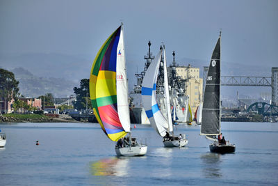 Sailboats in sea against sky