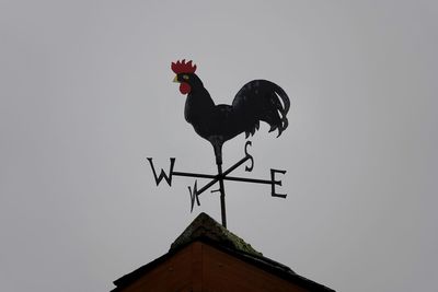 Low angle view of weather vane against clear sky