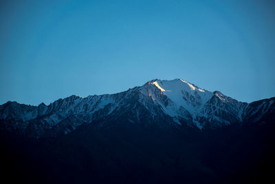 Scenic view of snowcapped mountains against clear blue sky
