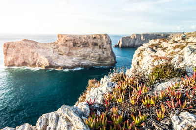 Rock formations by sea against sky