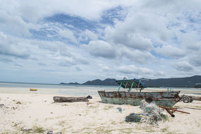 Scenic view of beach against cloudy sky