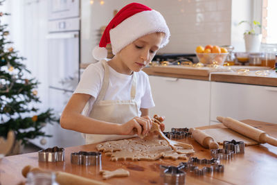 Cute boy making cookies at home