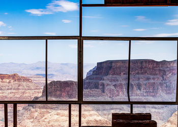 Scenic view of mountains against sky seen through window