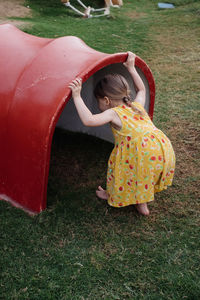 Little toddler girl playing on the kids playground. hide and seek game . entertainment