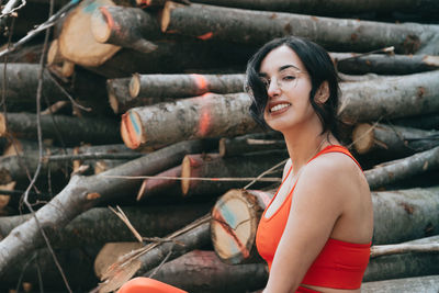 Portrait of smiling young woman sitting in forest