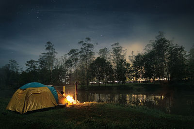 Camping tent by lake at dusk