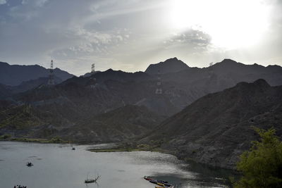 Scenic view of lake by mountains against sky