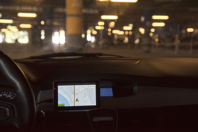 Illuminated street seen through car windshield at night