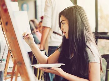 Side view of woman painting at studio