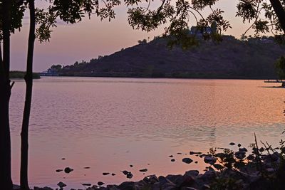 Scenic view of lake against sky at sunset