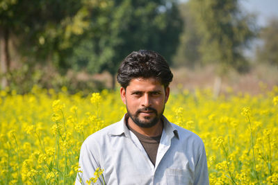 Young indian farmer at black mustard field