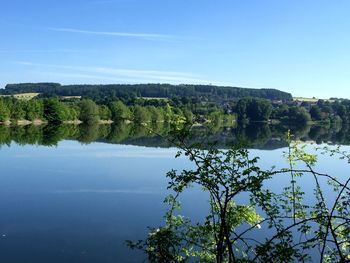 Scenic view of lake against clear blue sky