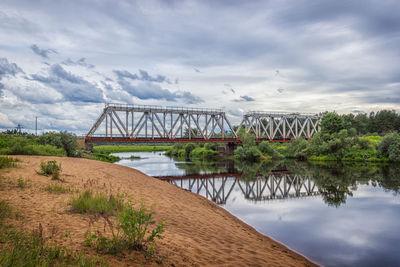 View of bridge over river against cloudy sky