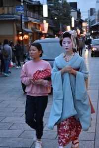 Women walking on street in city at night