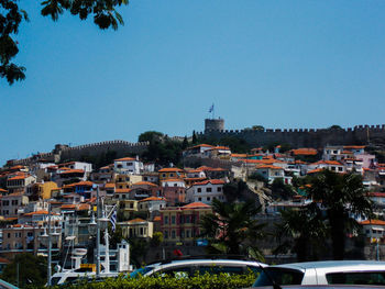 Buildings in city against clear blue sky