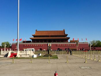 Group of people in front of building against clear blue sky