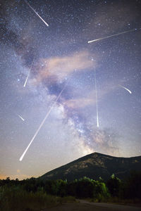 Low angle view of vapor trails in sky at night