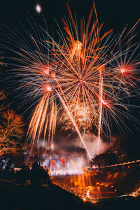 Low angle view of firework display at night